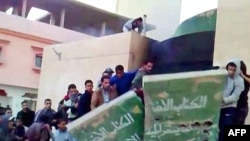 This video grab shows demonstrators destroying a monument to Muammar Qaddafi's Green book.