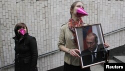 Актывістка з партрэтам Пуціна на акцыі ў Маскве