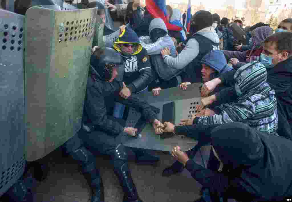 Pro-Russia protesters clash with police as they try to occupy a regional administration building in Donetsk.