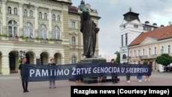 Aktivisti su sat vremena stajali na trgu sa transparentom na kojem je pisalo “Pamtimo žrtve genocida u Srebrenici”