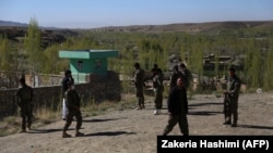 Afghan security personnel guard the site of an attack by Taliban militants on a government compound in Ghazni Province on April 12.