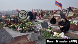 Armenians visit the graves of their relatives killed during the latest fighting over the breakaway Nagorno-Karabakh territory in Yerevan on December 12.