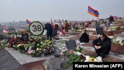Ermeniler bölünip aýrylan Daglyk-Garabag sebitiniň üstünde turan soňky söweşde öldürilen dogan-garyndaşlarynyň mazarlaryny zyýarat edýärler. 12-nji dekabr, 2020 ý. Ýerewan. Ermenistan.