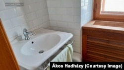 Hadházy Ákos szerint ez a fürdőszoba – a lecserélt, olcsóbb mosdóval – is azt példázza, hogyan avatkozik be Lévai Anikó az apósa nevén lévő beruházásba