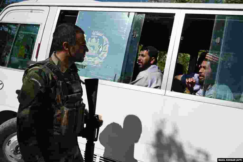 An Afghan National Army soldier talks with Taliban prisoners as they sit inside a vehicle during their release from Bagram prison.