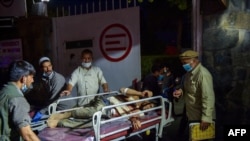 Медицински и болнички персонал доведоа повреден маж на лекување по двете силни експлозии пред аеродромот во Кабул на 26 август 2021 година.