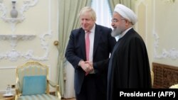 Iranian President Hassan Rohani (right) meets with British Foreign Secretary Boris Johnson in Tehran on December 10.