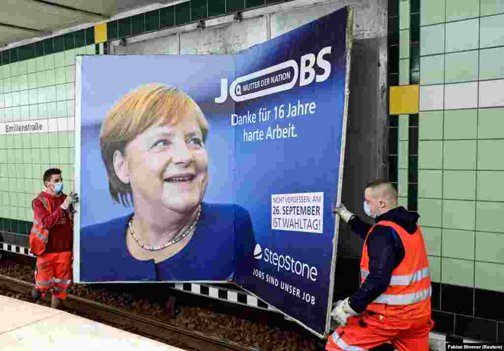 Munkások távolítanak el szeptember 24-én Hamburgban egy óriásplakátot Angela Merkel német kancellárról, amelyen ez olvasható: &bdquo;A nemzet édesanyja &ndash; köszönjük a tizenhat évnyi kemény munkát&rdquo;
