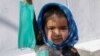 A young Afghan girl sells face masks on a road in Kabul in September.