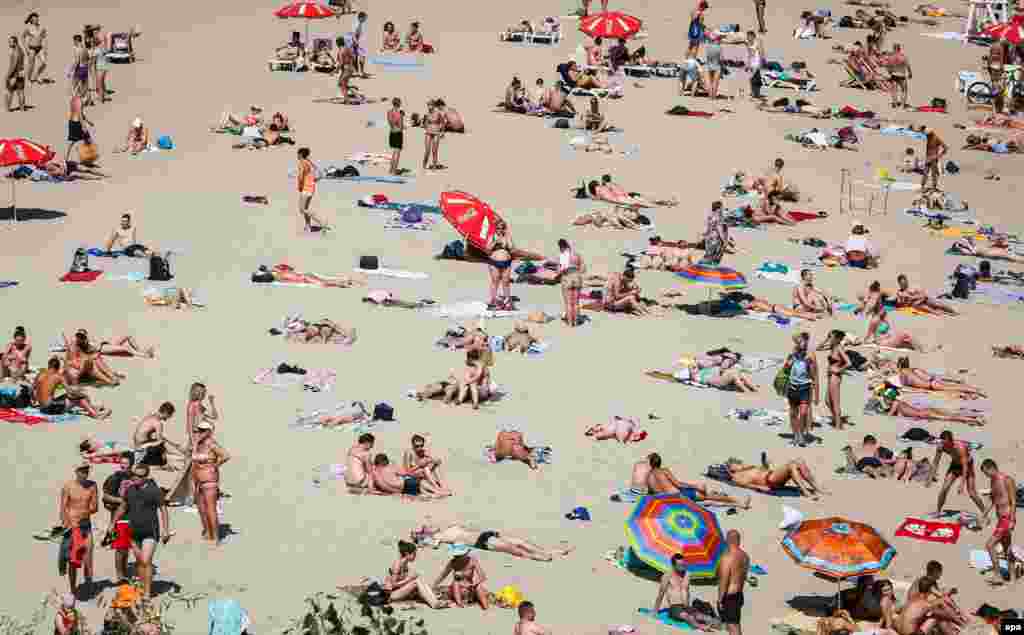 Ukrainians enjoy warm weather at a beach on the Dnipro River in Kyiv. (epa/Roman Pilipey)