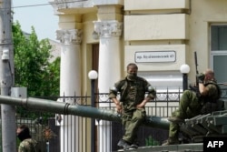 Члени групи «Вагнер» сидять на танку на вулиці в місті Ростов-на-Дону, 24 червня 2023 року