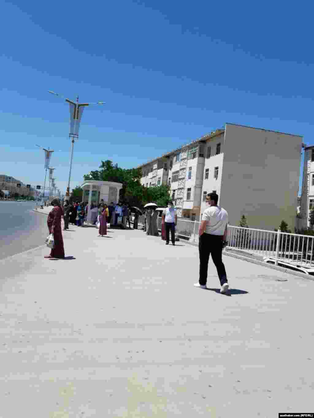 Aşgabat.&nbsp;Awtobus duralgasynyň ýanynda ulaga garaşýan adamlar.