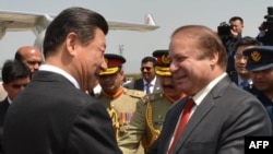 Chinese President Xi Jinping (L) is welcomed by Pakistani Prime Minister Nawaz Sharif after arriving in Islamabad on April 20.