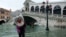 Чоловік із маскою ходить по затопленій вулиці у Венеції. Щорічну сезонну повінь мешканці міста називають &laquo;високою водою&raquo; (acqua alta), але цьогоріч вона сягнула небувалих розмірів&nbsp;