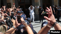 Armenia - Supporters greet a handcuffed Gagik Tsarukian as he is escorted out of an Investigative Committee building in Yerevan, July 22, 2026.