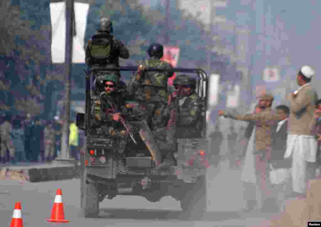 Pakistani security forces drive on a road leading to the Army Public School that came under attack by Taliban gunmen in Peshawar.