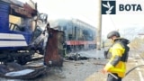 Një zjarrfikës shuan zjarret pasi një tren pasagjerësh u godit nga sulmet ruse me dronë në Shostka më 4 tetor 2025.