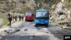 Pakistani security personnel inspect the site of a suicide attack in Khyber Pakhtunkhwa Province on March 26 that killed five Chinese engineers and a Pakistani driver.