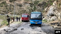 Security personnel inspect the site of a suicide attack Pakistan's Khyber Pakhtunkhwa Province that killed at least six people, including five Chinese workers. 
