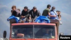 Amenia - Refugees from Nagorno-Karabakh ride in a truck upon their arrival at the border village of Kornidzor, September 27, 2023. 