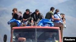 Беженцы из Нагорно-Карабахского региона едут в грузовике в приграничном селе Корнидзор. Армения, 27 сентября 2023 года