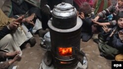 یوه کورنۍ بخارۍ ته راټوله شوې لاسونه ګرموي