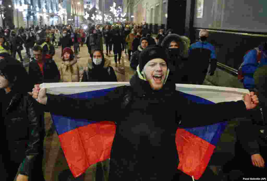 A man drapes a Russian flag across his back as he marches through Moscow in support of Navalny.