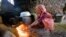 A girl lights a cooking fire in Tajikistan's Khatlon region.