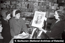 A bookshop employee shows high school students a poster of Soviet founder Vladimir Lenin in the provincial town of Tapa in 1960.