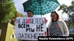 A woman holds a placard reading "You can't shut up everyone!" as journalists and supporters take part in a protest against Russia's "foreign agent" law in Moscow in September.