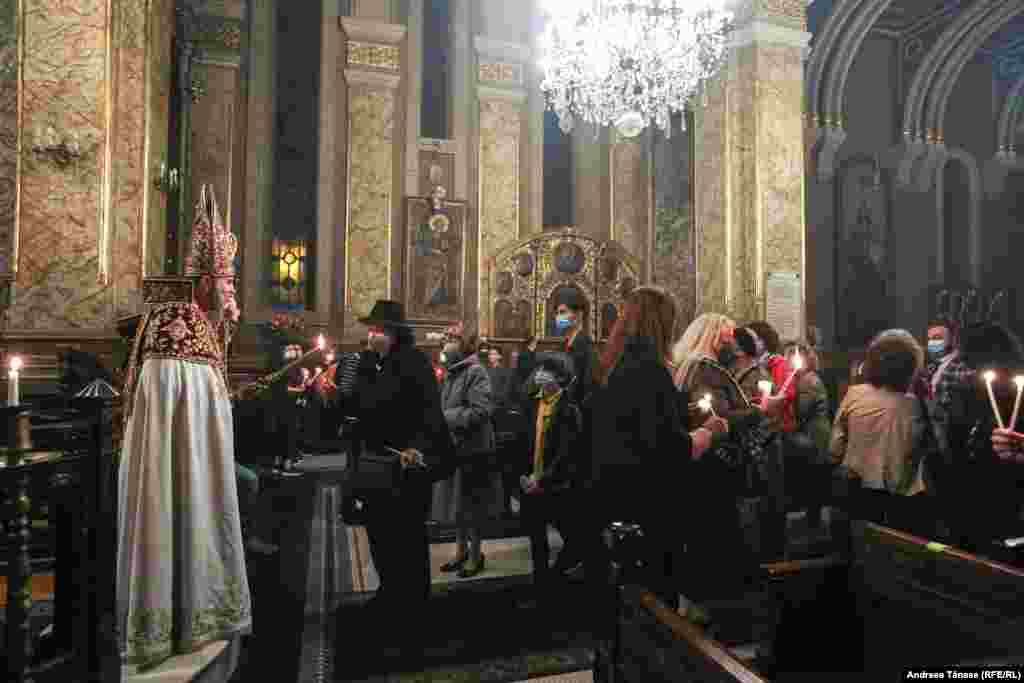 Episcopul Datev Hagopian &#238;mparte credincioșilor Lumina Sf&#226;ntă cu ocazia &#206;nvierii Domnului, &#238;n Catedrala Apostolică Armeană Sfinţii Arhangheli Mihail şi Gavriil (1911 – 1915) din Bucureşti, Rom&#226;nia. 