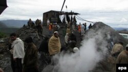 People gather around a coal mine that collapsed following heavy downpour in the Orakzai tribal agency in Kohat on March 13.
