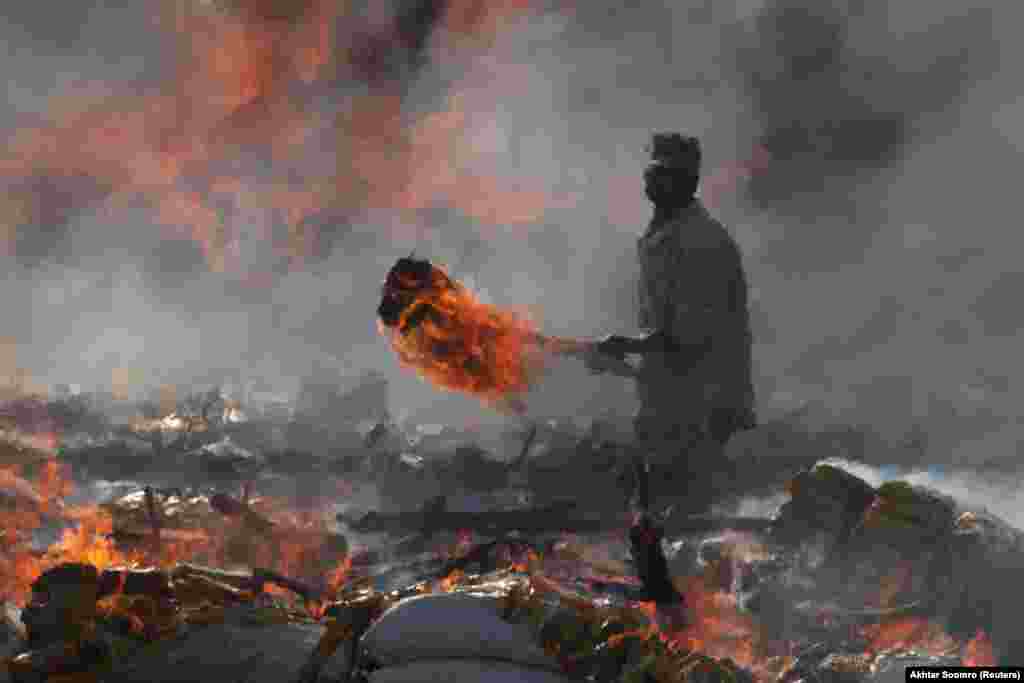 A Pakistani customs officer burns piles of confiscated contraband and narcotics destroyed during an event marking International Customs Day in Karachi on January 26. (Reuters/Akhtar Soomro)