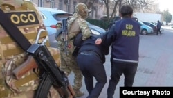 УКМКнын коррупцияга шектелген кызматкерин кармоо учуру. ИИМ тараткан сүрөт. 