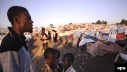 A man looks out over a tent city where many homeless Haitians are living in the wake of the disaster.