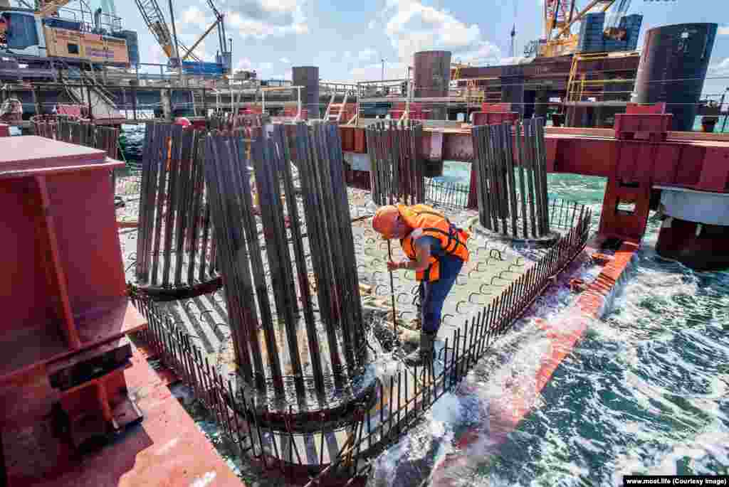 An engineer works as waves slap a pontoon. With the stakes high, Russian resources poured into the project. According to a&nbsp;New Yorker report, the building of new automobile roads in Russia was &quot;practically suspended&quot; while the Kerch bridge construction went ahead.&nbsp;