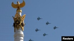 Военные самолеты кружат над небом Астаны во время парада в День защитника Отечества. 7 мая 2014 года.