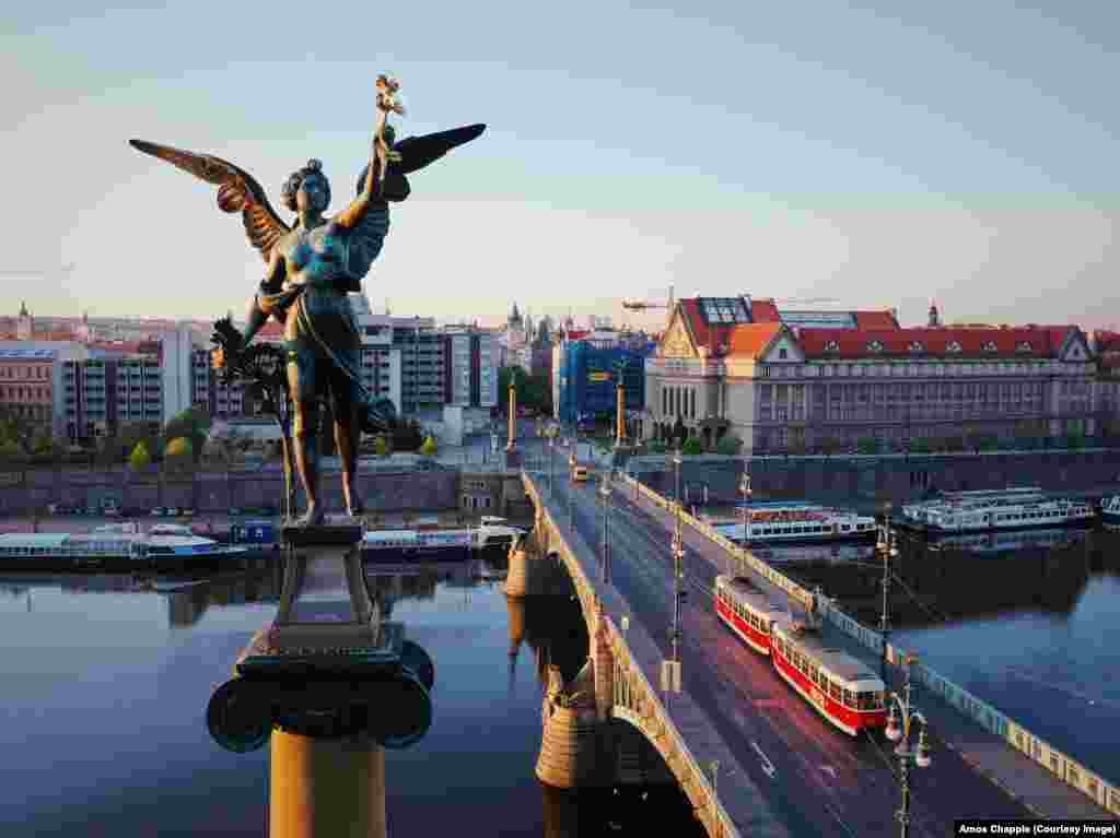 Jutarnje svetlo na jednoj od četiri krilate ženske figure koje stoje u uglovima mosta Čehuv. Figure, koje drže visoko podignute pozlaćene vence napravio je Antonin Pop (1815&ndash;1915). &nbsp;