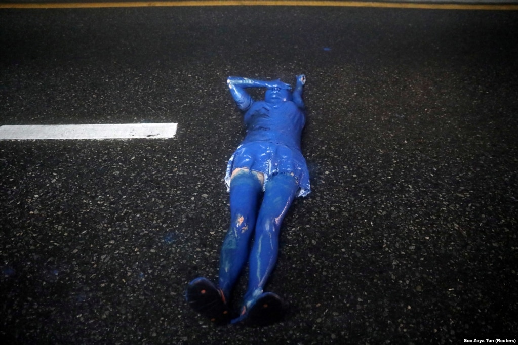 Ця активістка пофарбувалася у блакитний колір та лягла посеред дороги. Таким чином вона висловлює свою приналежність саме до продемократичних мітингувальників, тоді як колір протестувальників-роялістів &ndash; жовтий. Фото від 17 жовтня