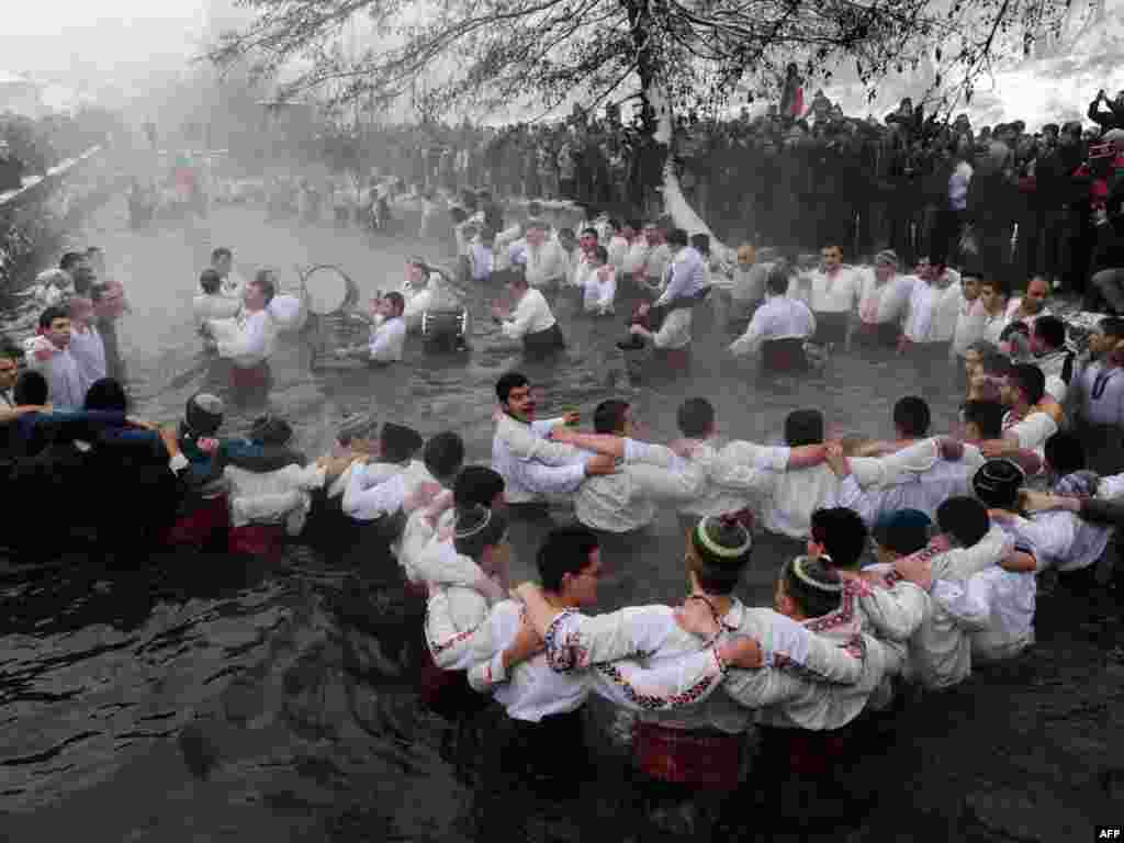 Bulgarian men perform the traditional Horo dance in the river Tundzha in the town of Kalofer. - Bulgarians also celebrate Epiphany Day in the water. According to tradition, whoever retrieves the cross from the water will be healthy throughout the year, as well as everyone who dances in the water.