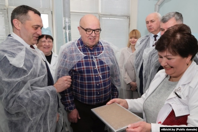 Kryetari i Komitetit Ekzekutiv Rajonal të Vitsebsk, Alyaksandr Subotsin (majtas), drejtori i fabrikës Alyaksandr Shumakher (në qendër) dhe Kryetari i Bordit të Drejtorëve të fabrikës Manalit, Akif Hasymau (djathtas) gjatë një vizite në fabrikën e prodhimit, në mars 2024.