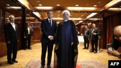 File photo - France's president Emmanuel Macron (L) greets Iranian president Hassan Rouhani at the Millennium Hotel near the United Nations on September 18, 2017, in New York. 