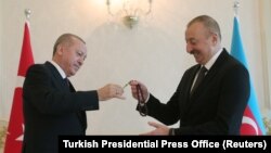 Azerbaijan -- Azeri President Ilham Aliyev receives prayer beads from his Turkish counterpart Tayyip Erdogan in Baku, February 25, 2020.