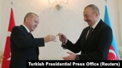 Azerbaijani President Ilham Aliyev receives prayer beads from his Turkish counterpart, Recep Tayyip Erdogan, during a meeting in Baku on February 25.