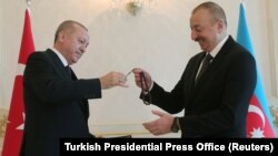 Azerbaijan -- Azeri President Ilham Aliyev receives prayer beads from his Turkish counterpart Tayyip Erdogan in Baku, February 25, 2020