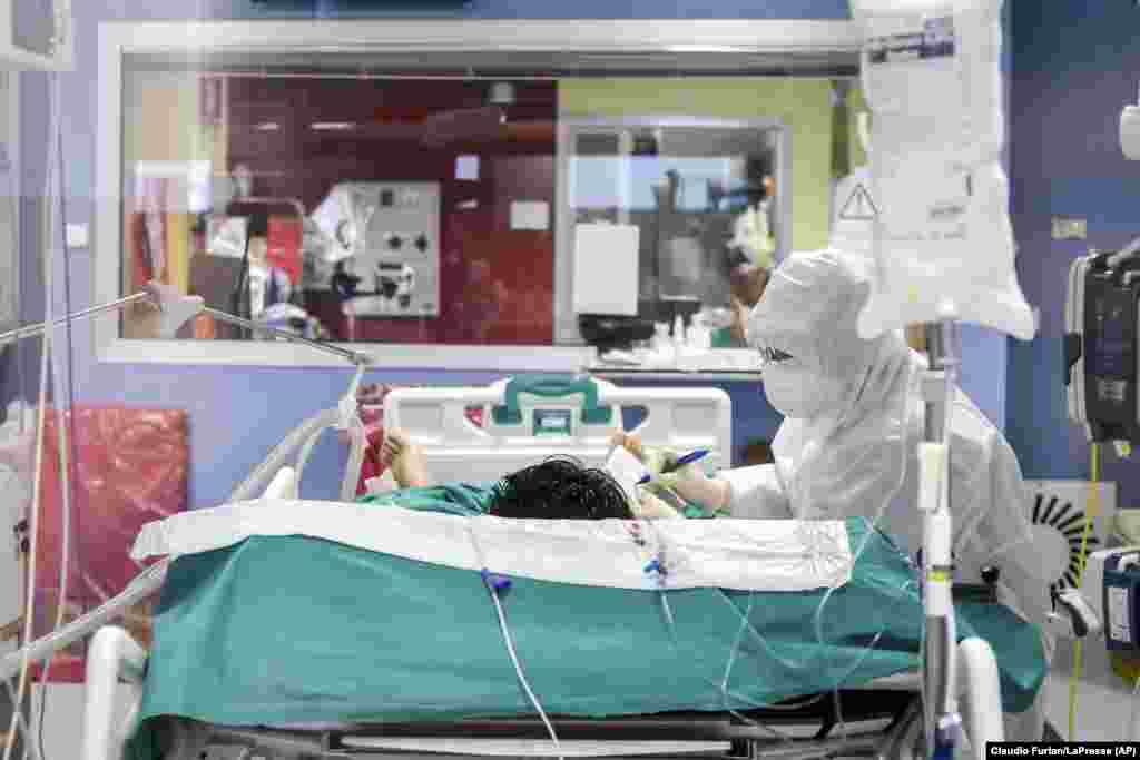 A medical staffer writes a note to communicate with a coronavirus patient in the intensive-care unit of Bassini Hospital in Cinisello Balsamo, near Milan, Italy. (AP/Claudio Furlan/LaPresse)