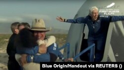 Бизнисменот милијардер Џеф Безос и пионерската жена авијатичарка Воли Фанк излегуваат од нивната капсула по нивниот лет со ракетата Њу Шепард на Blue Origin на првиот суборбитален лет без пилот во светот во близина на Ван Хорн, Тексас, САД, 20 јули 2021 година