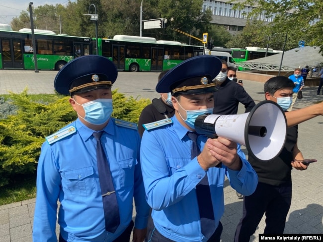 Представители прокуратуры предупреждают протестующих о «незаконности» протеста без согласия местных властей. Алматы, 18 сентября 2021 года