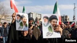 Удзельнікі мітынгу ў Тэгеране трымаюць плякаты з партэтамі бацькі і сына Хамэнэі, 9 сакавіка 2026 году