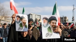 Iran - People hold placards with an image of Iran's new supreme leader, Mojtaba Khamenei, with late Iranian Supreme Leader Ayatollah Ali Khamenei, during a gathering in Tehran, March 9, 2026.